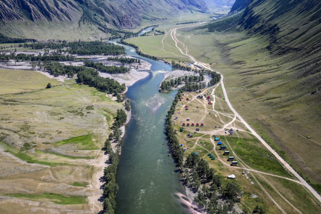 Fluss in einer wunderschönen Tal-Landschaft mit umgebenden Bergen