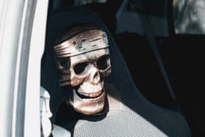 Totenkopfmaske auf dem Auto-Beifahrersitz Gefahr