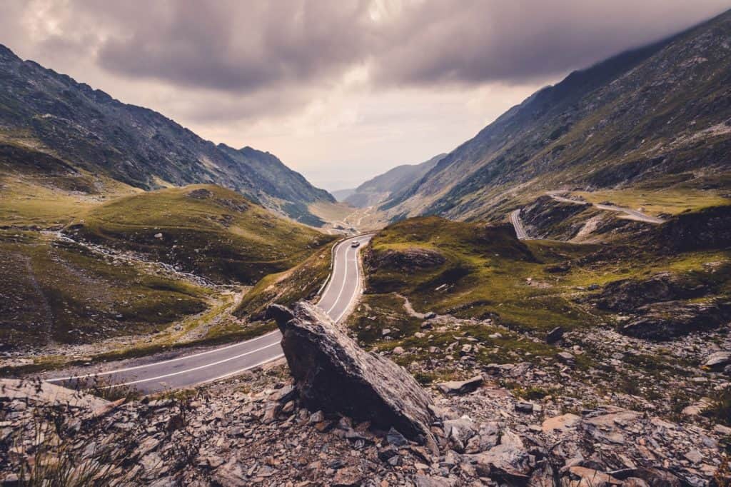 Steinige Straße mit Auto und Bergen