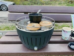 Frühstückszubereitung mit dem Lotusgrill. Rösten von Brötchen und erwärmen von Wasser für den Kaffee beim Camping im Auto